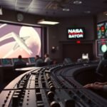 A vintage NASA Mission Control console with various switches and monitors from the Apollo era.