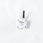 A small electronic monitoring device for gut health attached to white fabric.