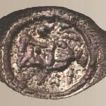 An ancient copper signet ring with Greek lettering and pottery imagery found in the Judean Desert.