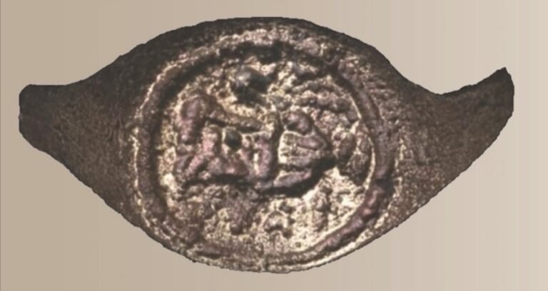 An ancient copper signet ring with Greek lettering and pottery imagery found in the Judean Desert.
