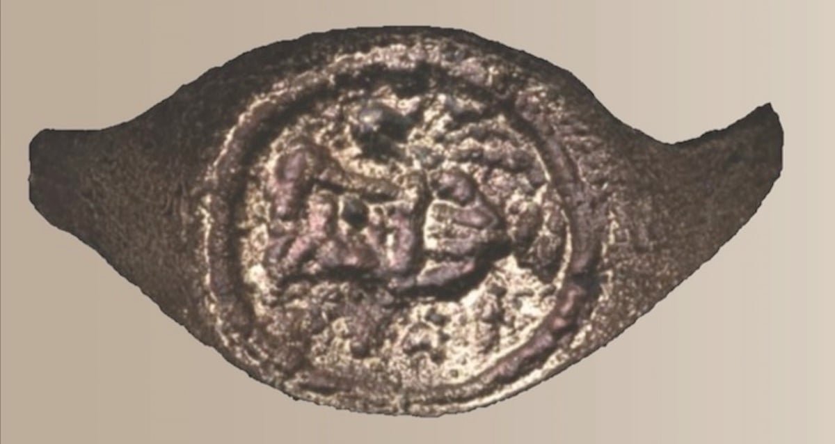 An ancient copper signet ring with Greek lettering and pottery imagery found in the Judean Desert.