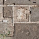 Ruins of the ancient school complex in Mieza, Greece, featuring stone columns and mosaic floors