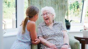 A healthy elderly person smiling while gardening in a sunny outdoor environment.