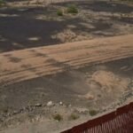 Aerial view of the Las Playas Intaglio fish carving in the Arizona desert with visible damage from machinery